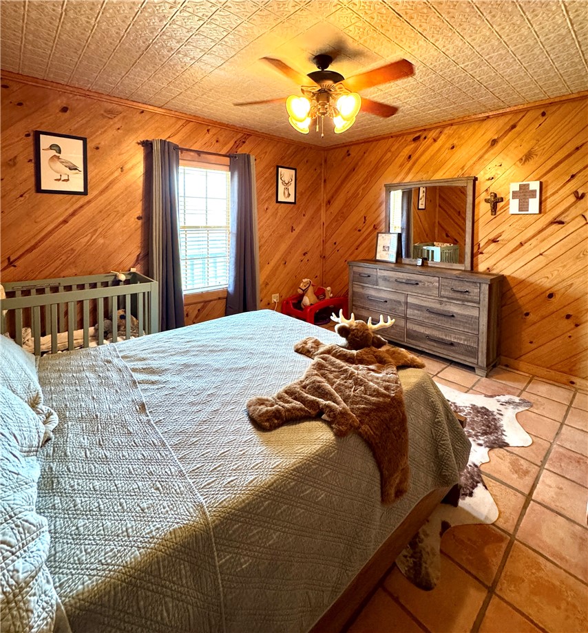 5567 County Road 1441 Mathis, TX 78368 - Photo 17 of 28 a bedroom with a bed a window and a chandelier