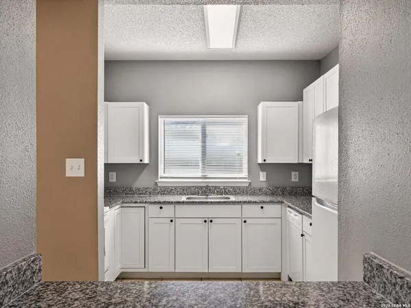 a bathroom with a granite countertop sink and a mirror