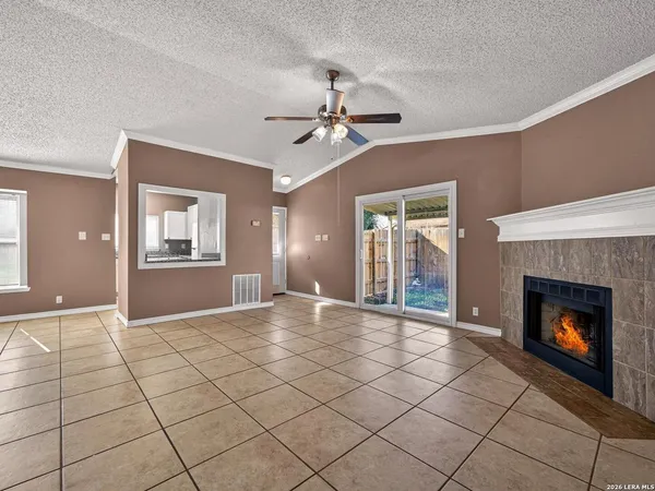 a view of an empty room with window and fireplace
