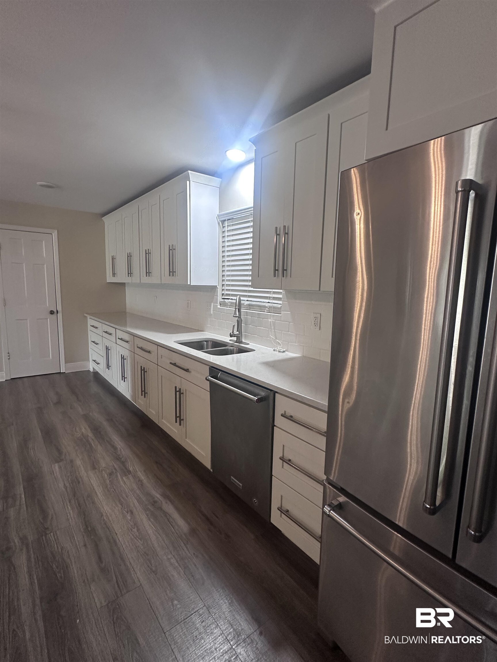 2785 Sowell Road Brewton, AL 36426 - Photo 16 of 24 Kitchen featuring stainless steel appliances, dark wood finished floors, white cabinets, backsplash, and light stone counters