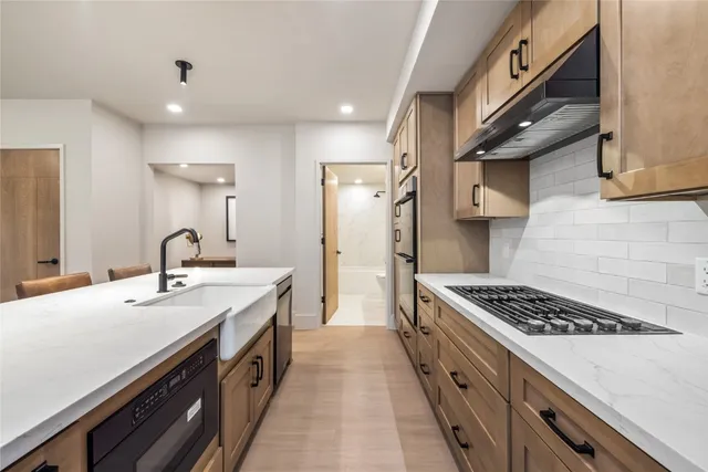 a kitchen with a sink appliances and cabinets