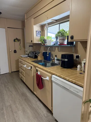 a kitchen with kitchen island granite countertop a sink cabinets and wooden floor