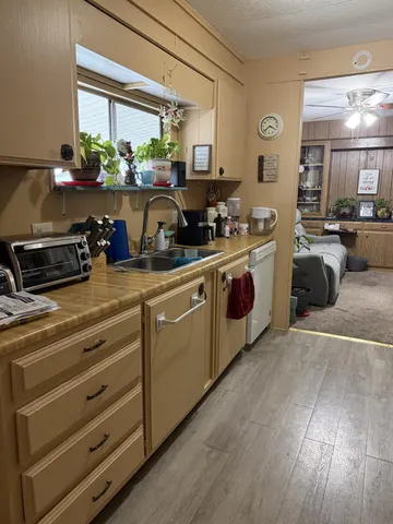 a kitchen with refrigerator a stove and wooden floor