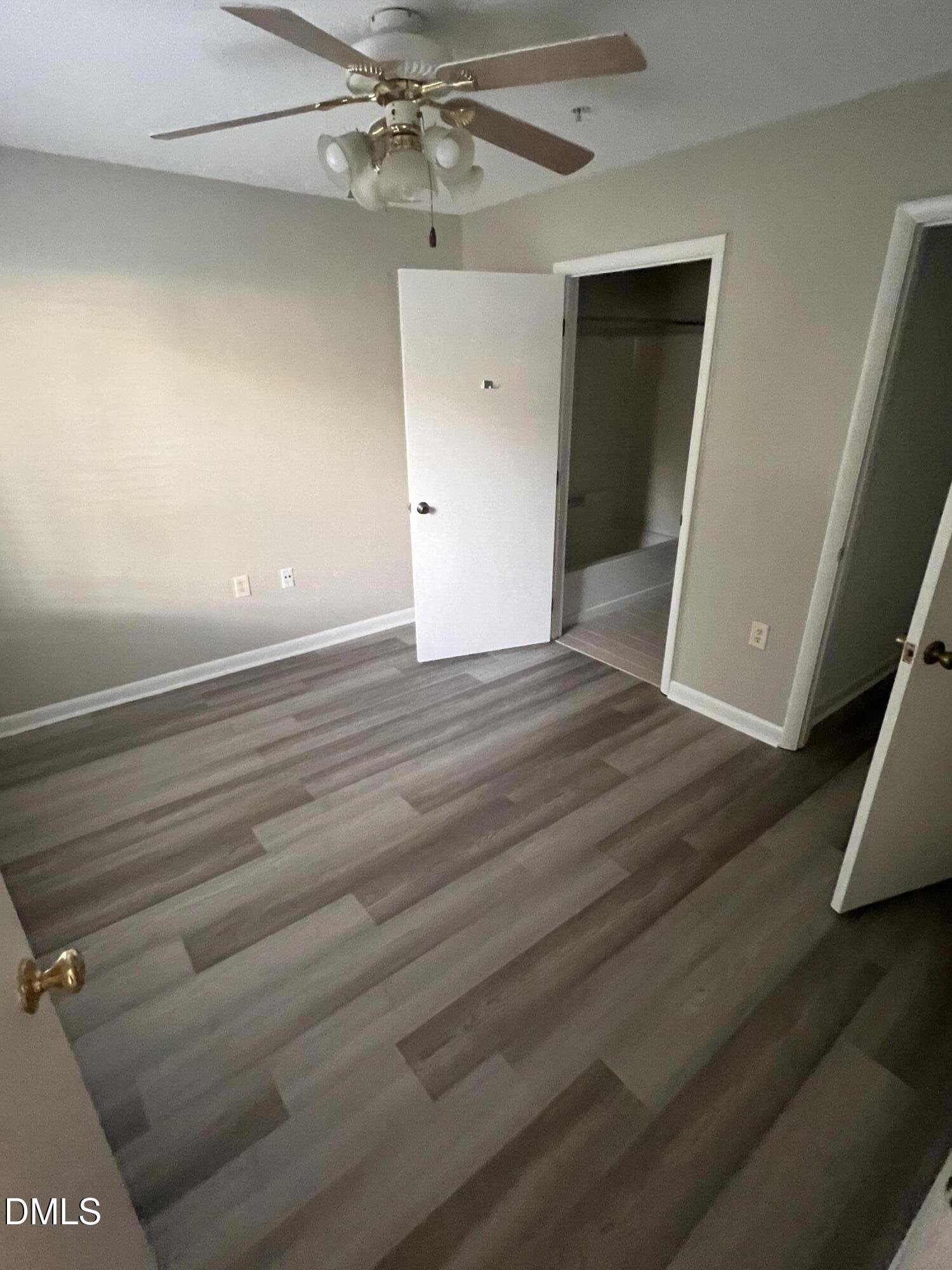 1431 Collegiate Circle, Unit 101 Raleigh, NC 27606 - Photo 10 of 11 en empty room with wooden floor and fan