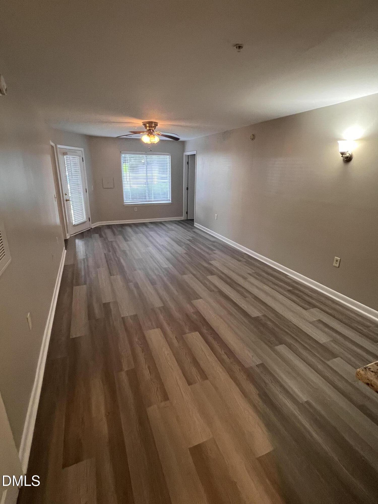 1431 Collegiate Circle, Unit 101 Raleigh, NC 27606 - Photo 4 of 11 wooden floor in an empty room with a window