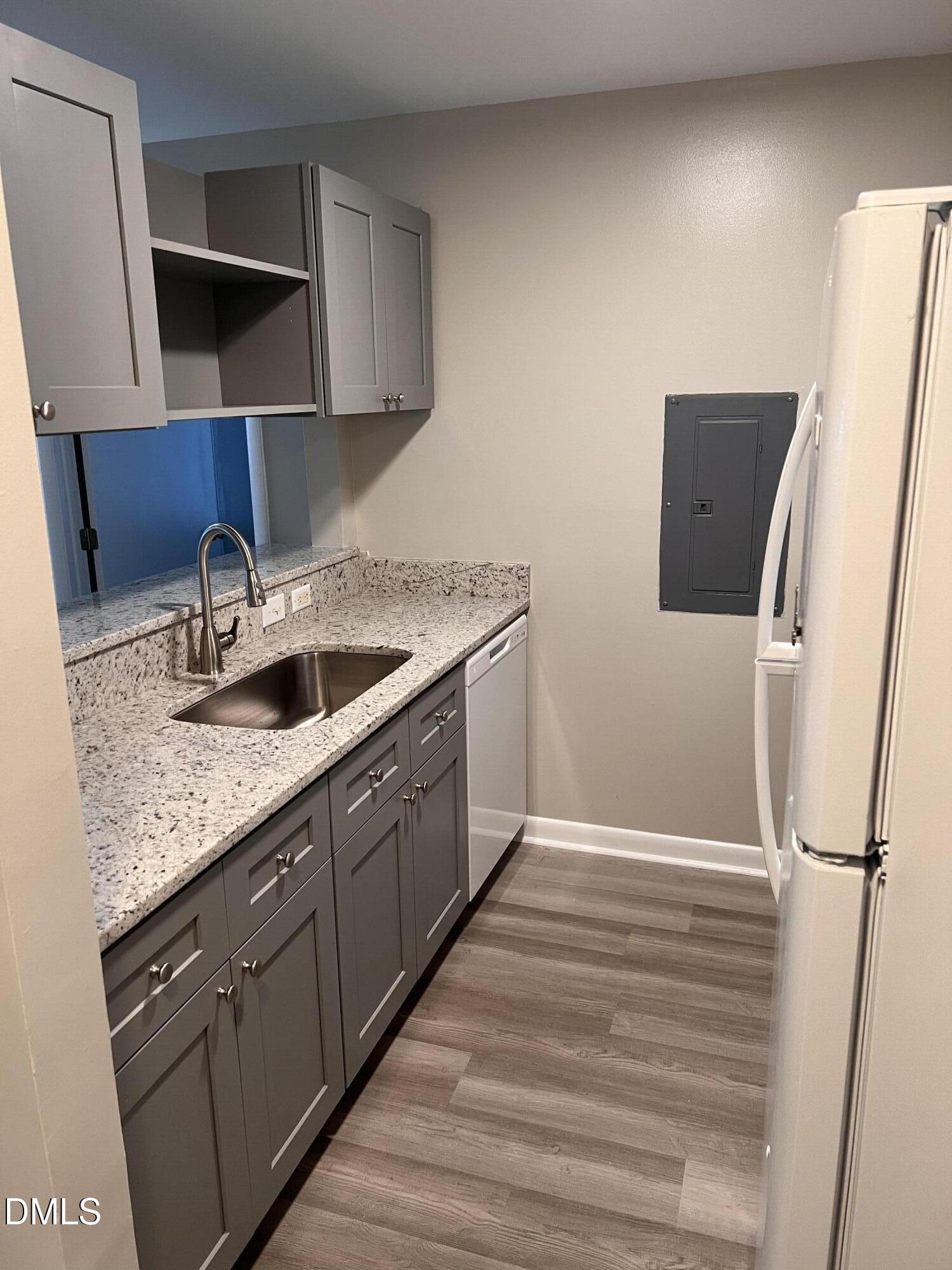 1431 Collegiate Circle, Unit 101 Raleigh, NC 27606 - Photo 5 of 11 a kitchen with a sink and a refrigerator