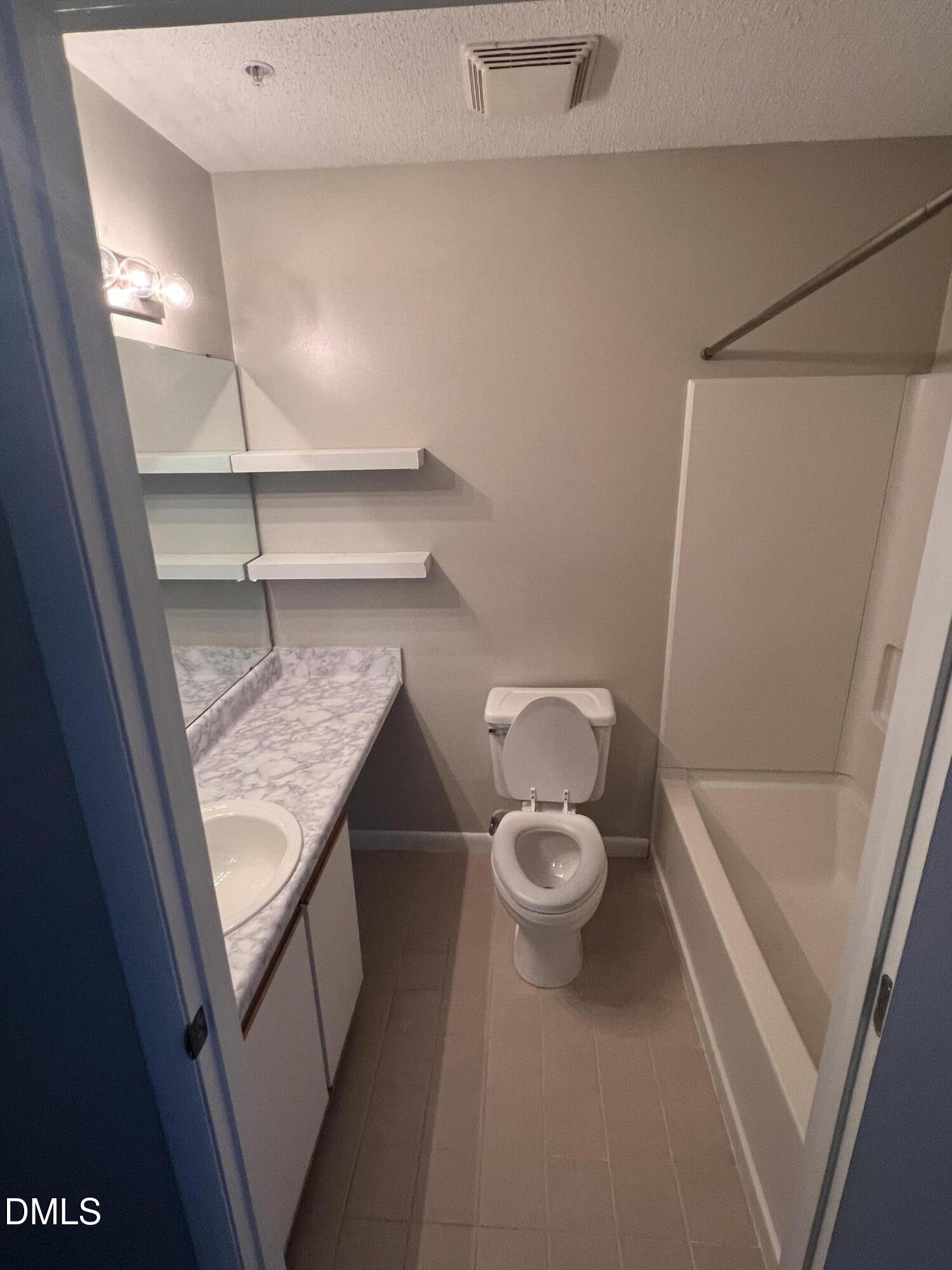 1431 Collegiate Circle, Unit 101 Raleigh, NC 27606 - Photo 6 of 11 a bathroom with a granite countertop toilet and a sink