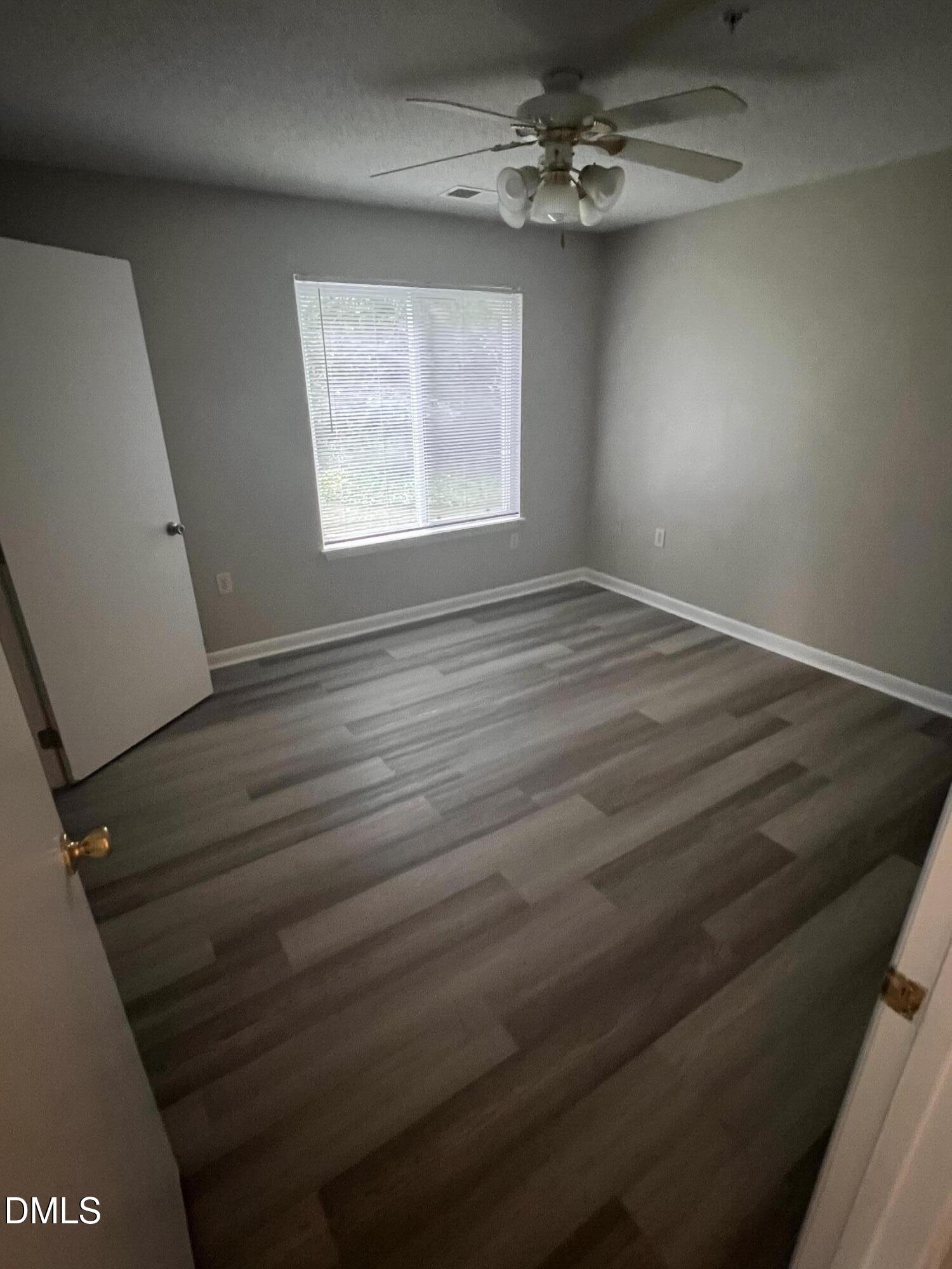 1431 Collegiate Circle, Unit 101 Raleigh, NC 27606 - Photo 8 of 11 wooden floor in an empty room with a window