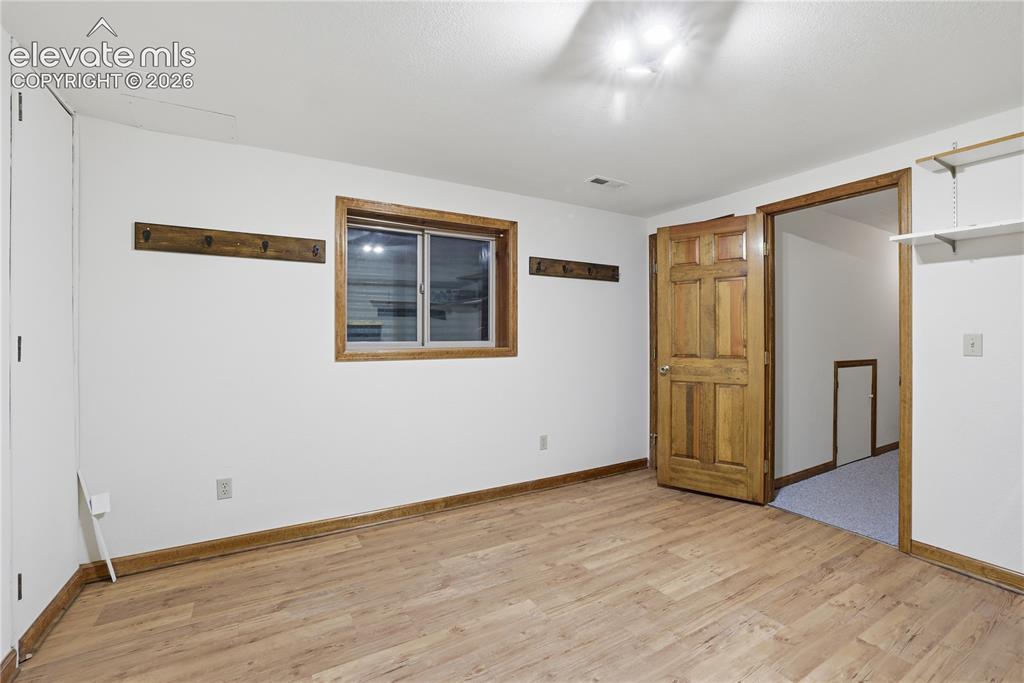 18190 Forest View Road Monument, CO 80132 - Photo 40 of 50 a view of an empty room with wooden floor and a window