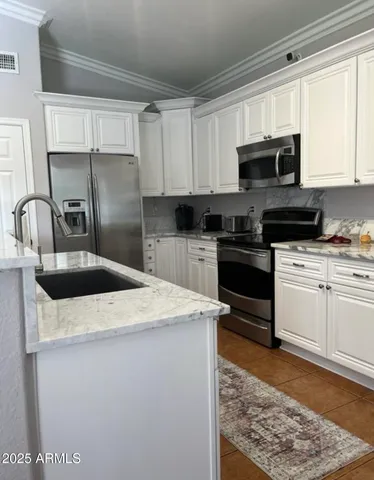 a kitchen with stainless steel appliances granite countertop a sink stove microwave and refrigerator