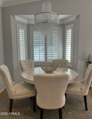 a living room with a table chairs and a window