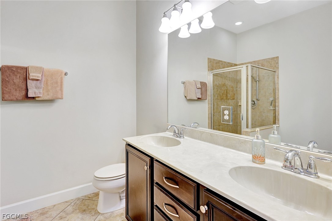 10879 Rutherford Road Fort Myers, FL 33913 - Photo 14 of 36 a bathroom with a sink a toilet and a large mirror