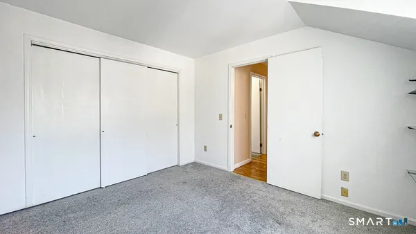 a view of an empty room with a window and kitchen