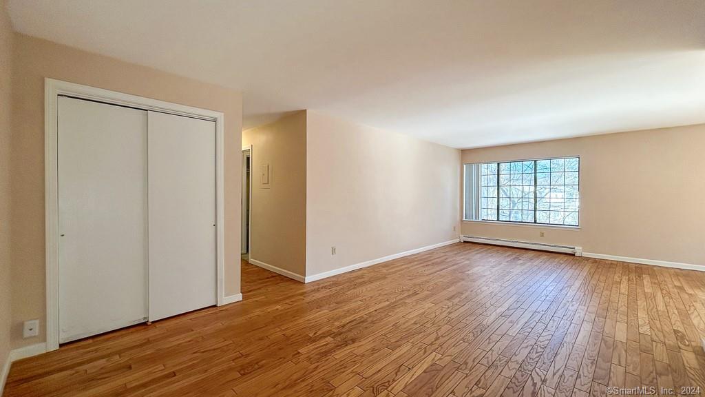8 Derby Court, Unit 8 Brookfield, CT 06804 - Photo 16 of 26 an empty room with wooden floor and windows