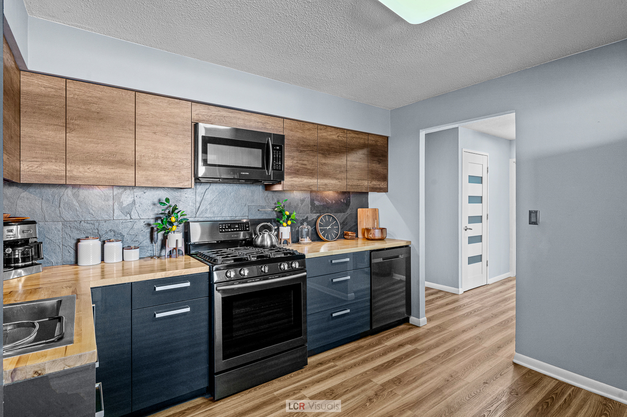 8815 West Golf Road, Unit 10C Niles, IL 60714 - Photo 7 of 27 a kitchen with stainless steel appliances granite countertop a stove a sink and a microwave