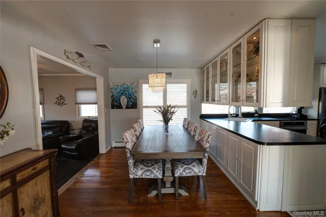 a large kitchen with granite countertop a large counter top furniture and a wooden floor