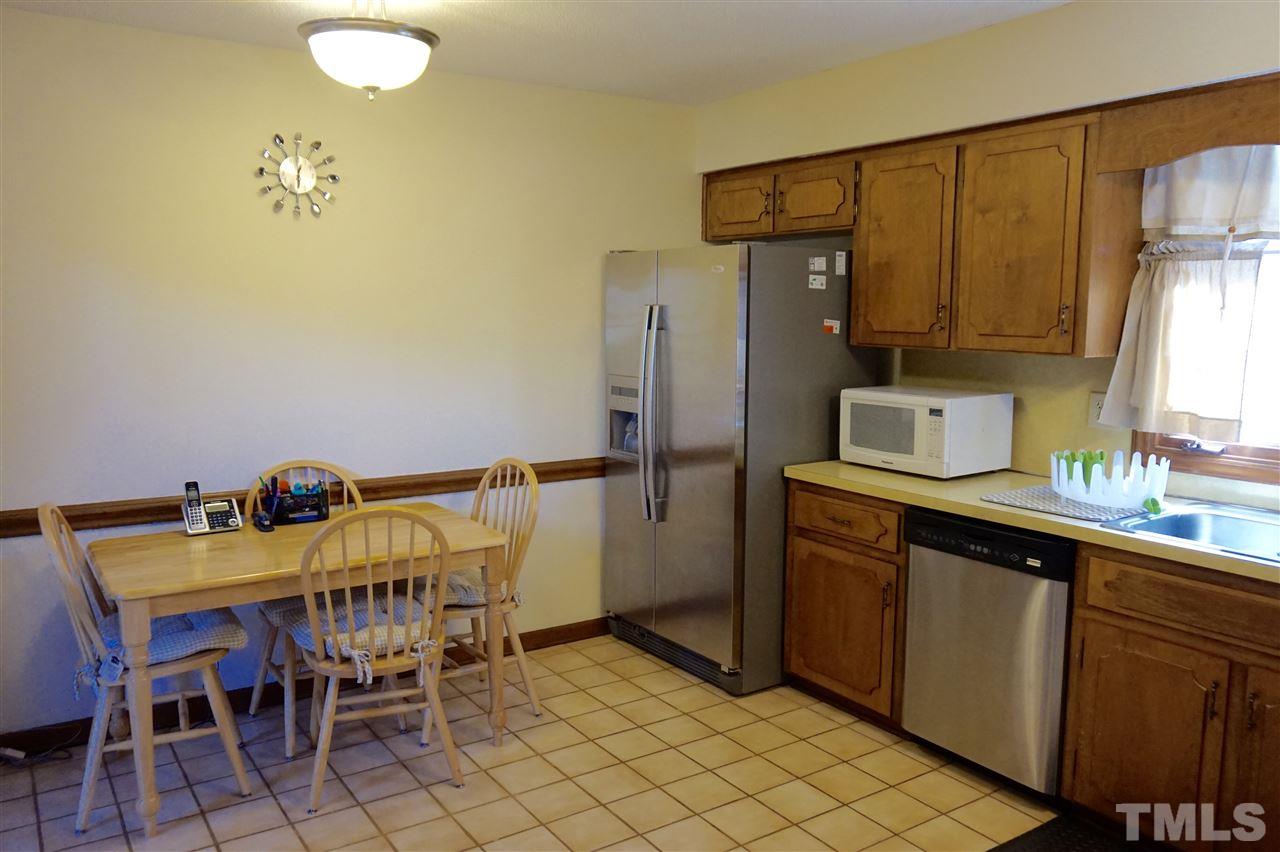 8605 Maidstone Court Raleigh, NC 27613 - Photo 5 of 13 a kitchen with a sink chairs and refrigerator