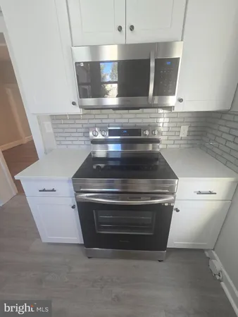 a stove top oven sitting inside of a kitchen