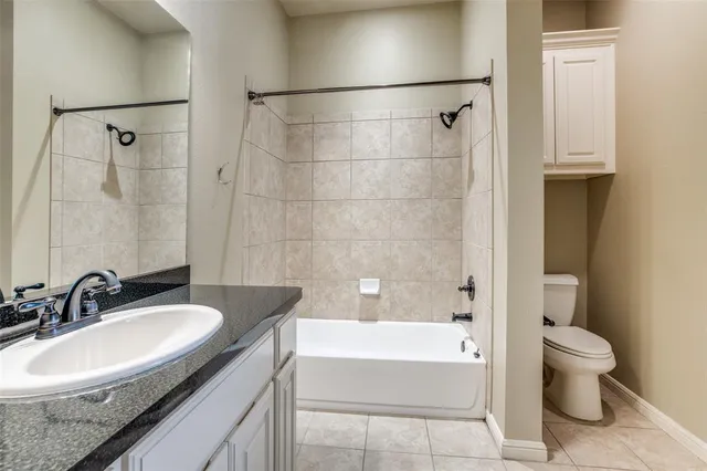 a bathroom with a granite countertop sink a toilet and bathtub