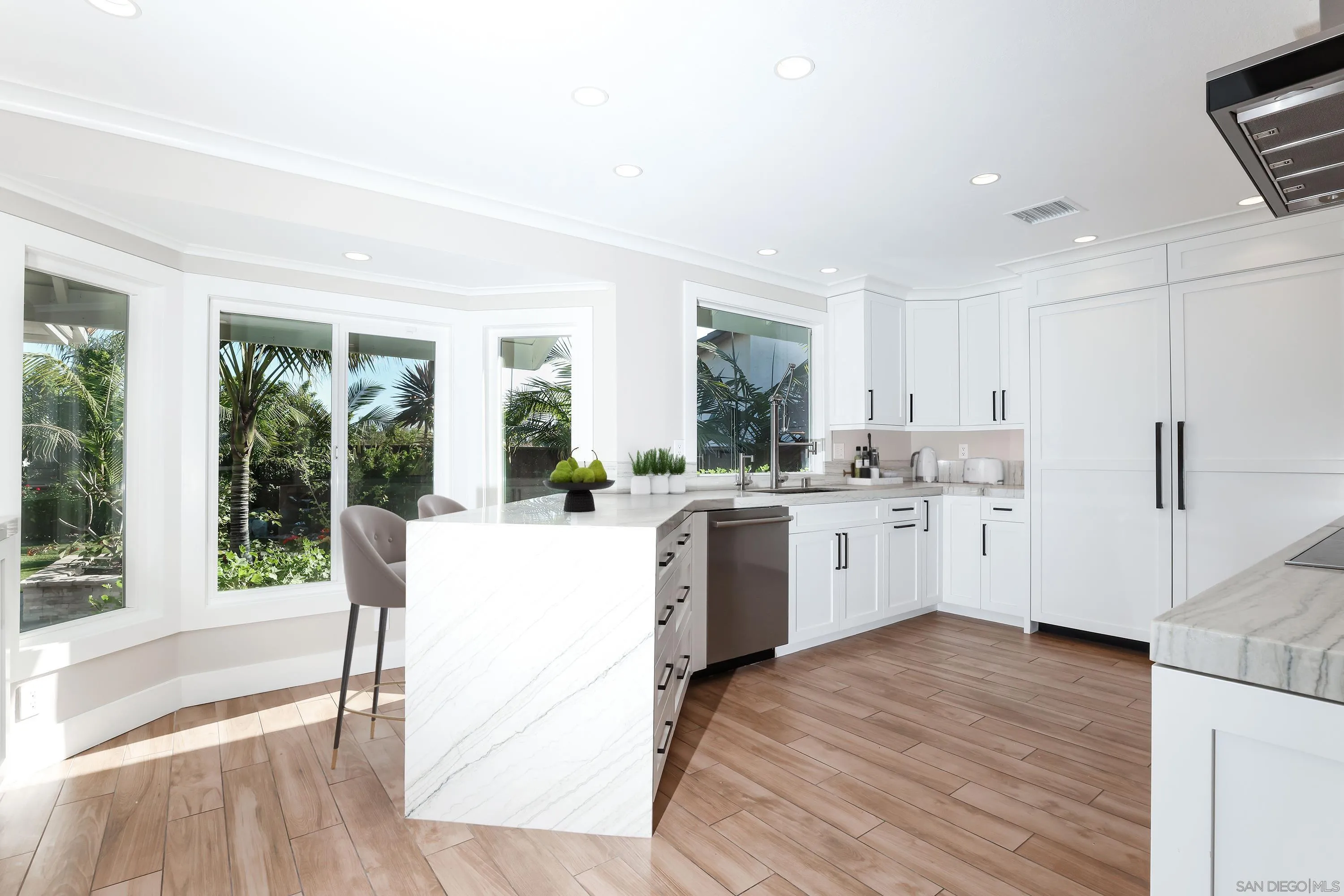2102 Wandering Road Encinitas, CA 92024 - Photo 7 of 37 a kitchen with a sink stove and white cabinets with wooden floor