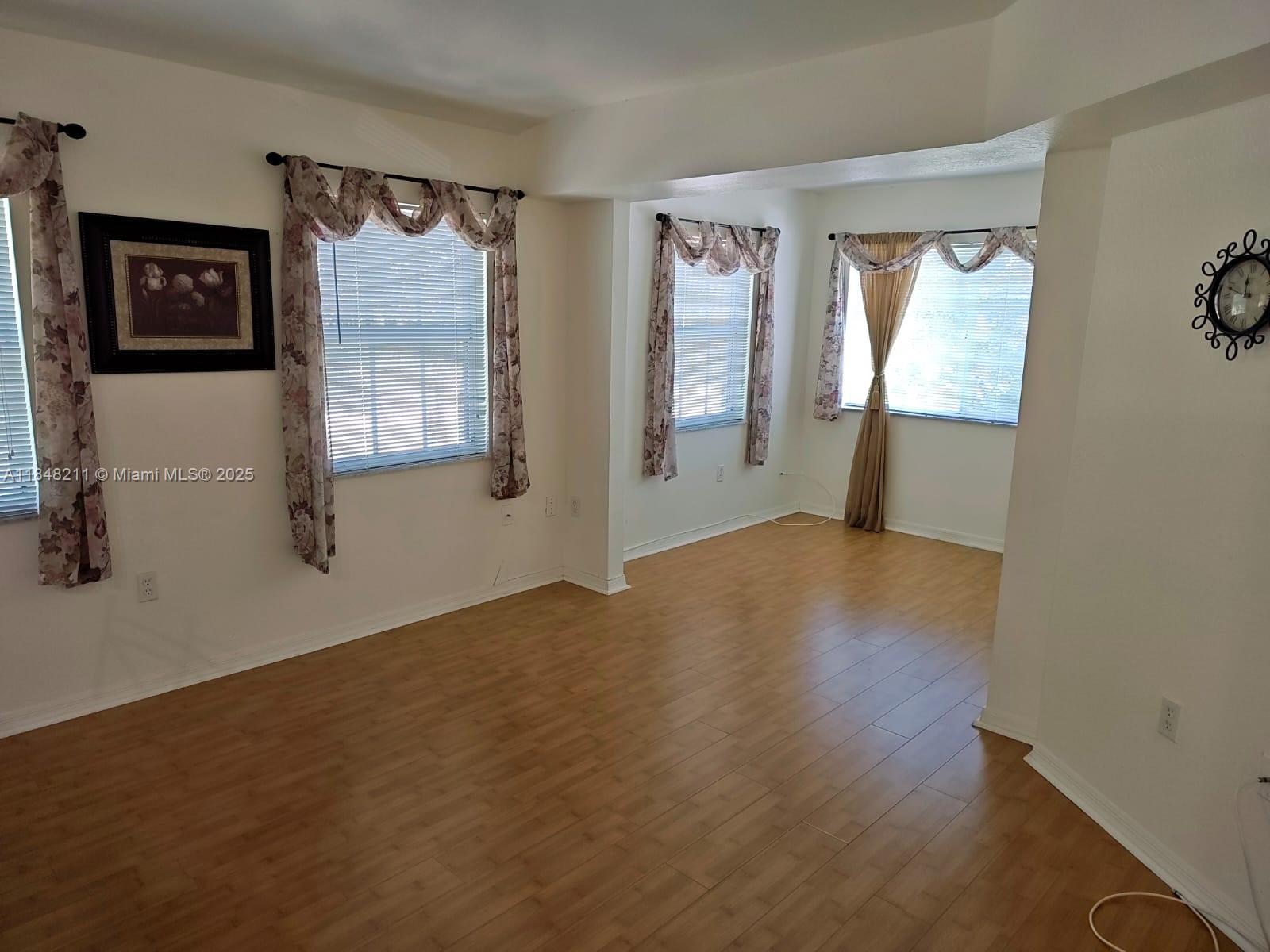 2586 Centergate Drive, Unit 307 Miramar, FL 33025 - Photo 16 of 43 a view of an empty room with wooden floor and a window