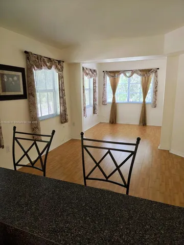 a living room with a table chairs and a window