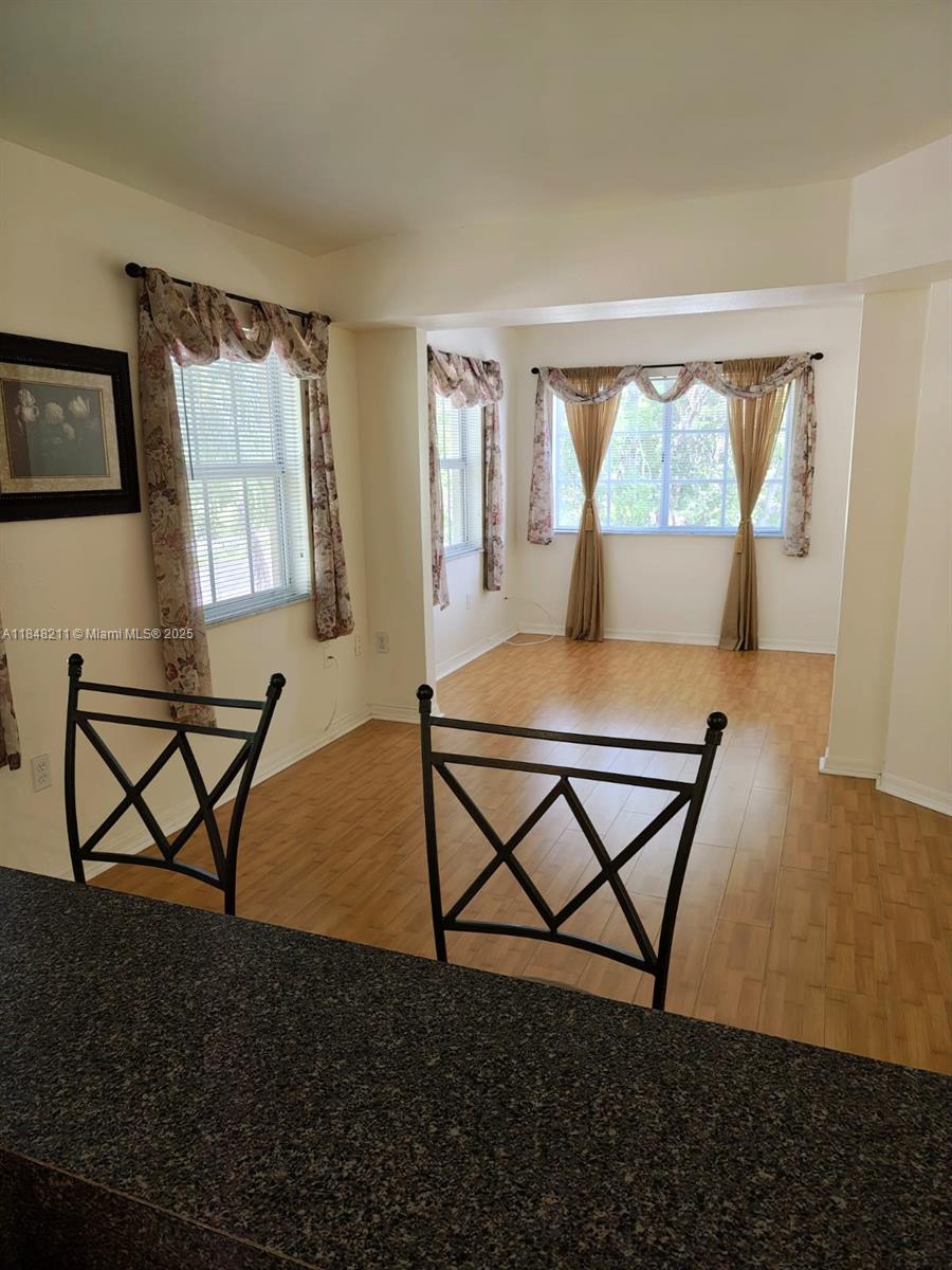 2586 Centergate Drive, Unit 307 Miramar, FL 33025 - Photo 22 of 43 a living room with a table chairs and a window
