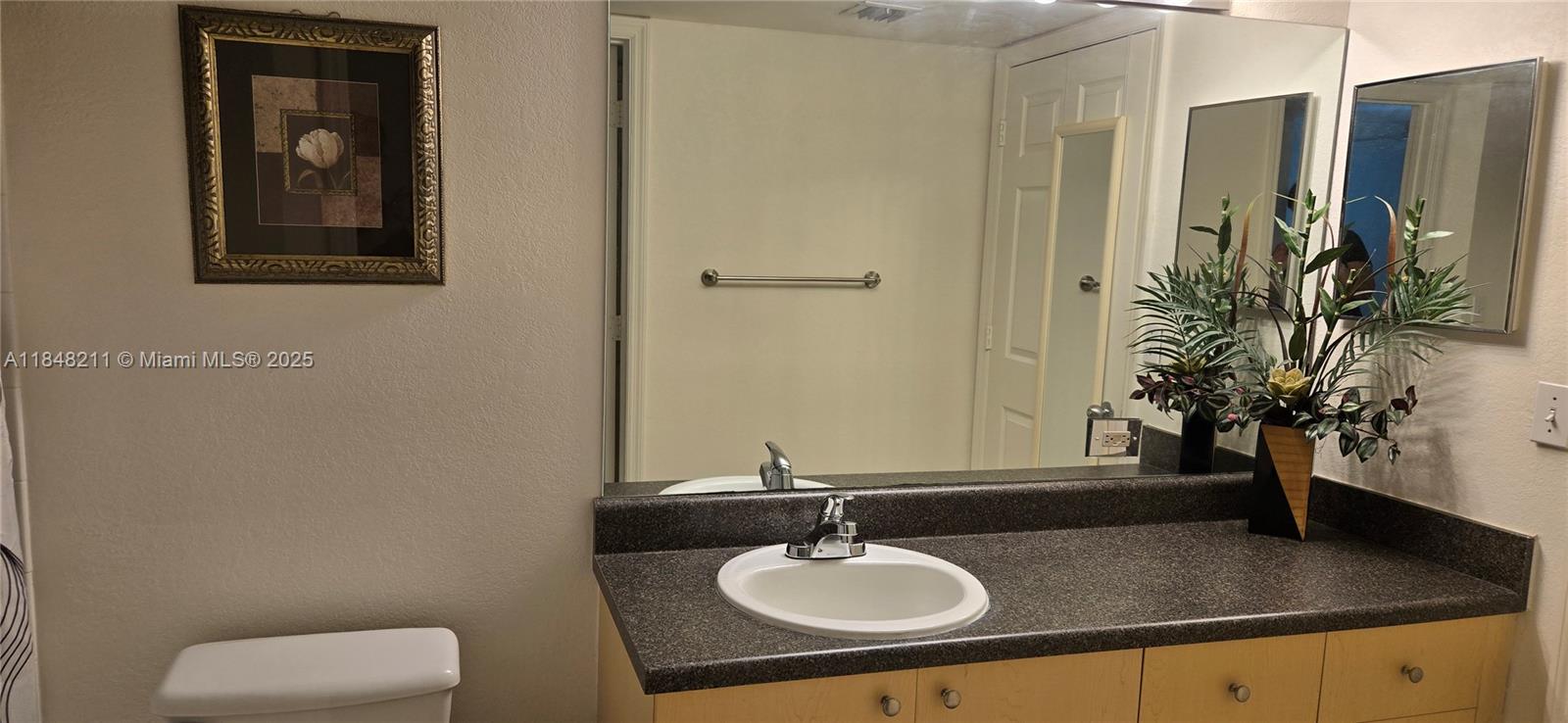 2586 Centergate Drive, Unit 307 Miramar, FL 33025 - Photo 31 of 43 a bathroom with a granite countertop sink and a mirror