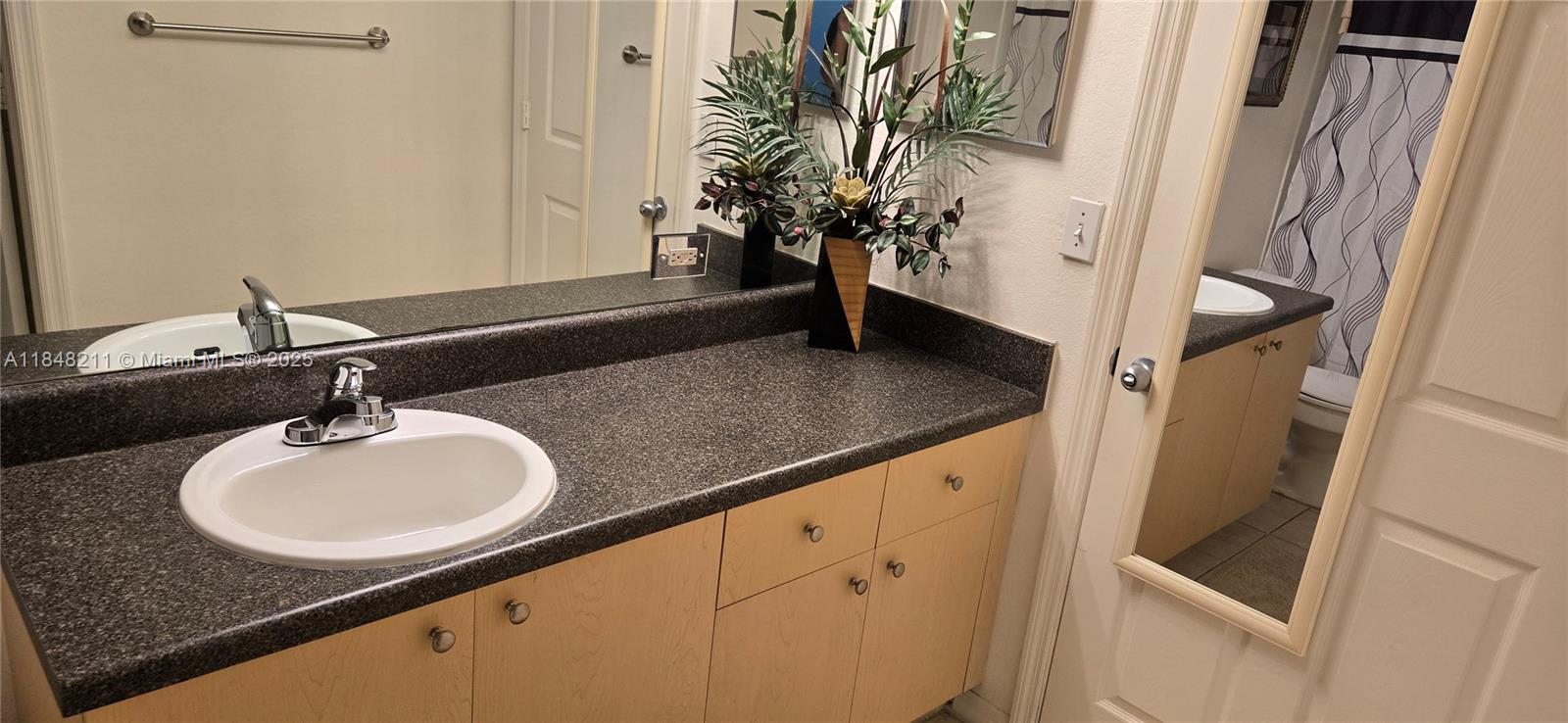 2586 Centergate Drive, Unit 307 Miramar, FL 33025 - Photo 32 of 43 a bathroom with a sink and a mirror