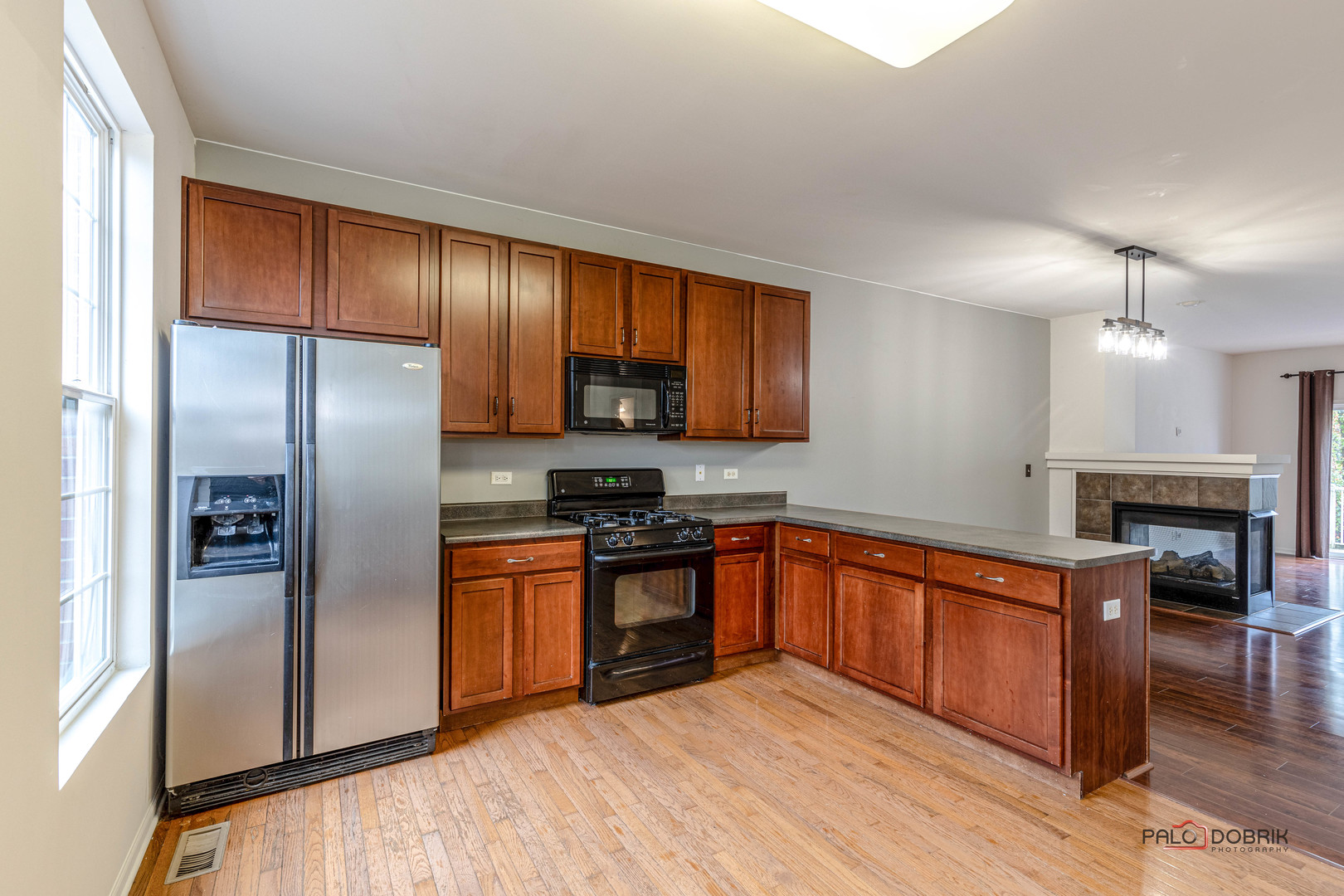 260 Comstock Drive, Unit 260 Elgin, IL 60124 - Photo 17 of 30 a kitchen with stainless steel appliances granite countertop a refrigerator a sink dishwasher a stove with wooden cabinets and floor