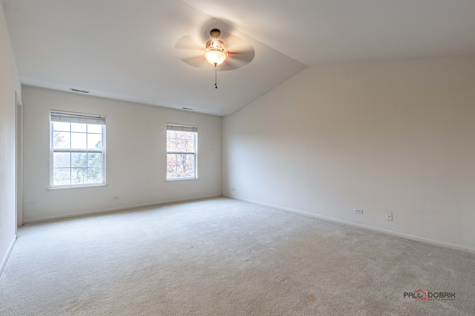 260 Comstock Drive, Unit 260 Elgin, IL 60124 - Photo 21 of 30 an empty room with a chandelier fan and windows