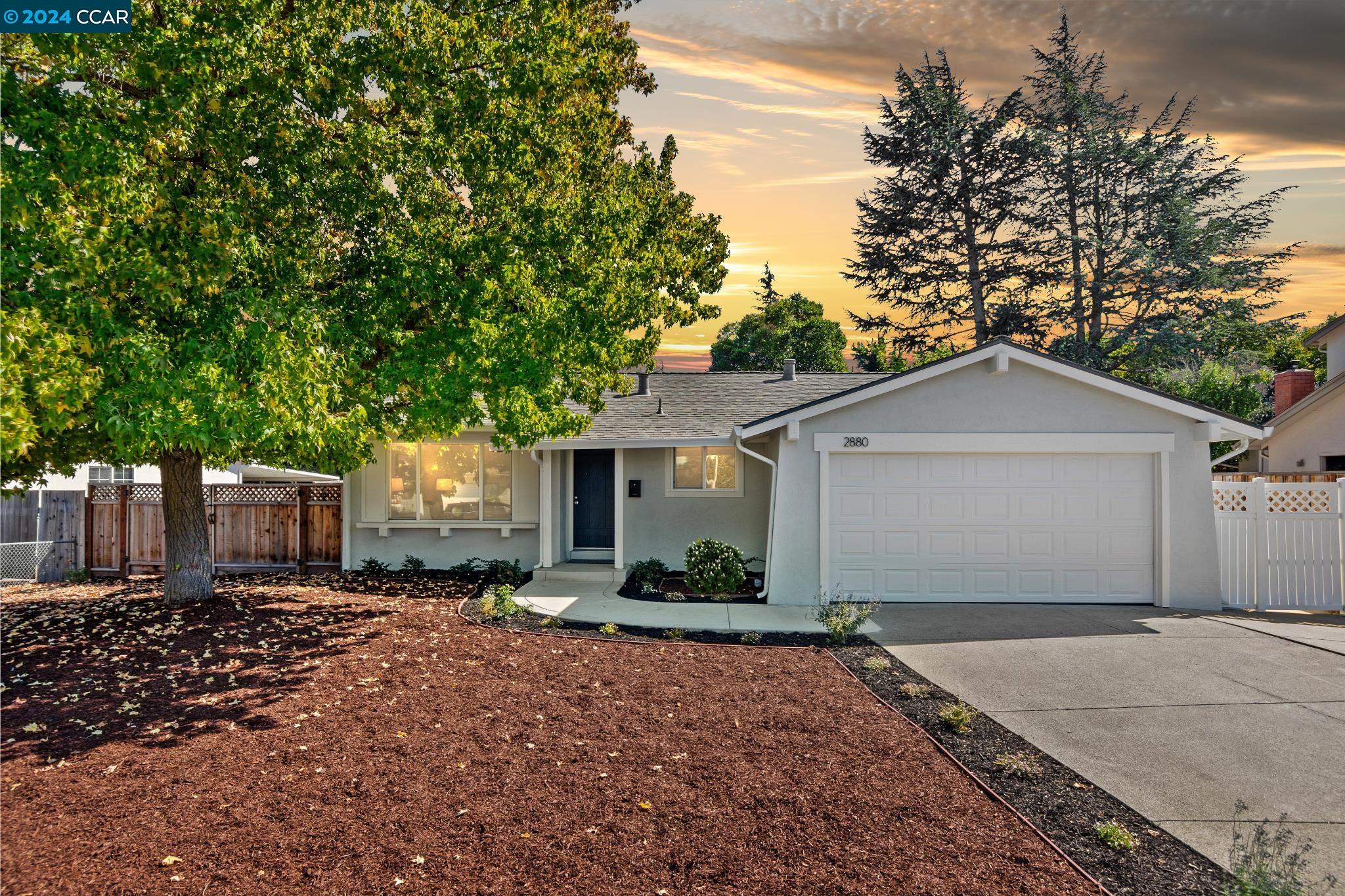 a front view of a house with a yard and trees