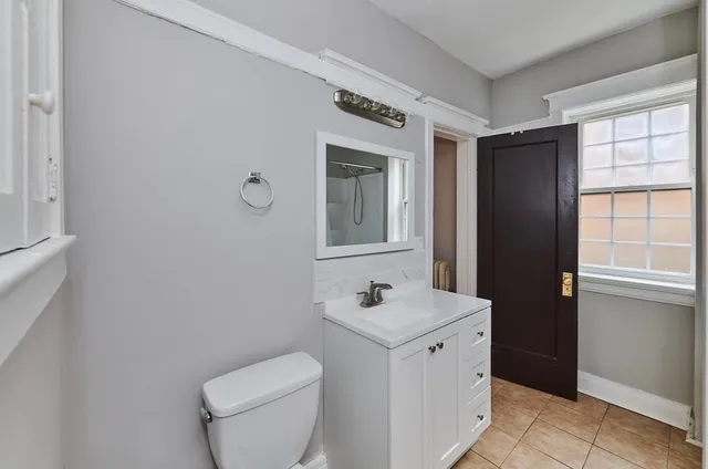 a bathroom with a toilet sink and mirror