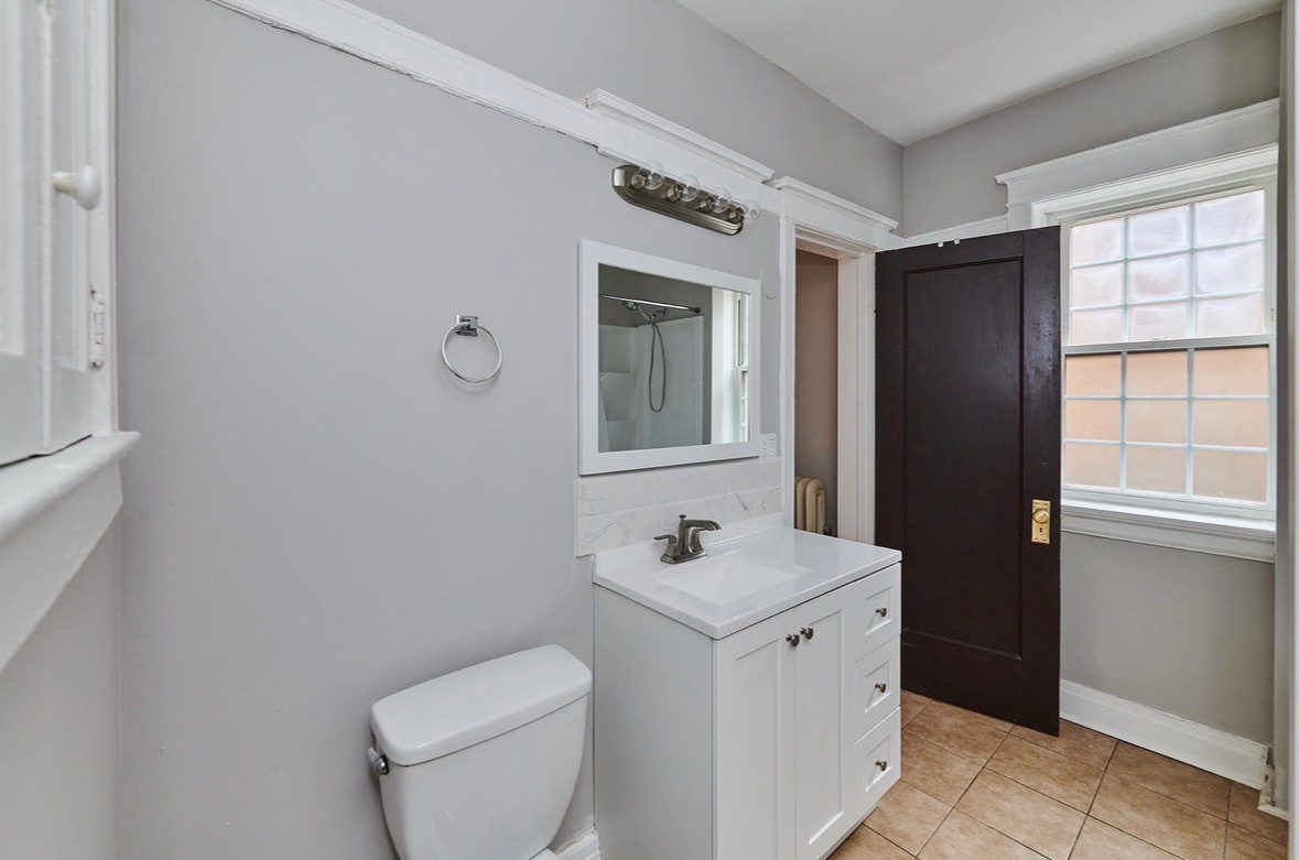 5436 West Ferdinand Street, Unit 3E Chicago, IL 60644 - Photo 14 of 16 a bathroom with a toilet sink and mirror