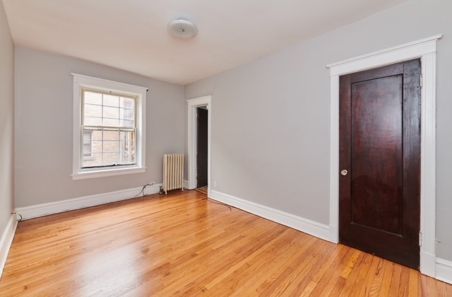 5436 West Ferdinand Street, Unit 3E Chicago, IL 60644 - Photo 6 of 16 a view of an empty room with wooden floor and a window