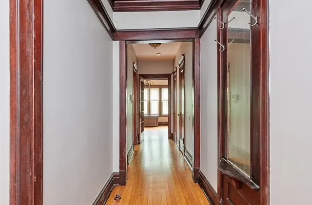 a view of a hallway with wooden floor and staircase