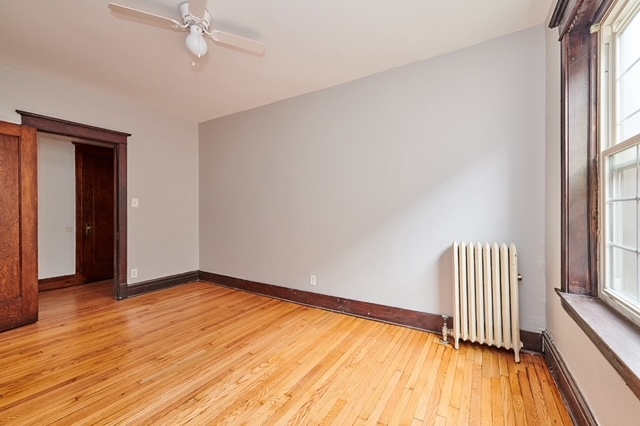 5436 West Ferdinand Street, Unit 3E Chicago, IL 60644 - Photo 8 of 16 a view of an empty room with wooden floor and a window
