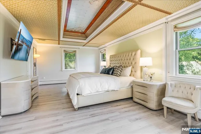 a bedroom with a white bed and a large window