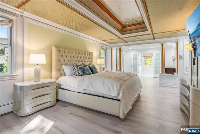 a spacious bedroom with a bed and a large mirror next to a window