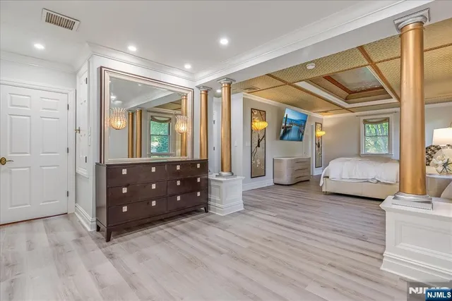 a spacious bedroom with a bed and wooden floor