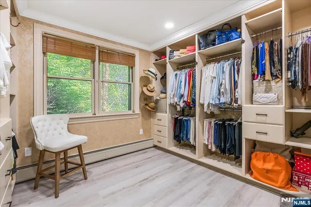 a view of walk in closet with clothes and shoes