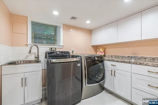 a utility room with sink dryer and washer