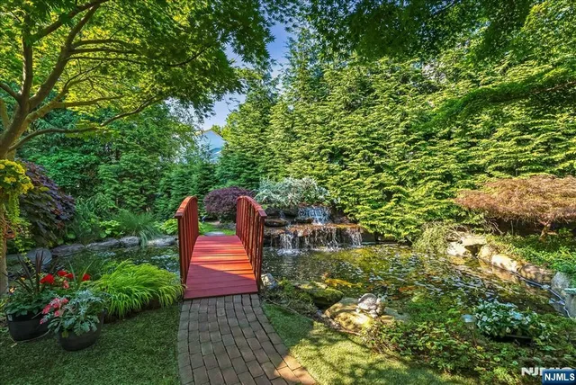 a backyard of a house with lots of green space and fountain
