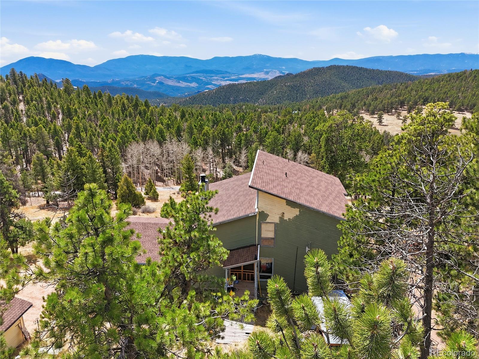 13108 Elsie Road Conifer, CO 80433 - Photo 13 of 49 a view of a lush green hillside and a houses