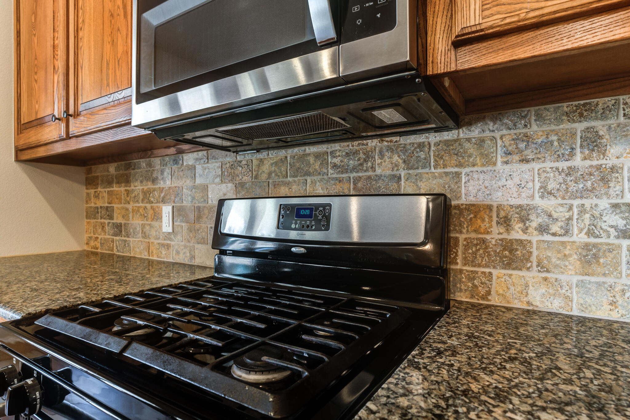 4802 Amherst Street Lubbock, TX 79416 - Photo 14 of 33 a stove sitting inside of a kitchen with white cabinets