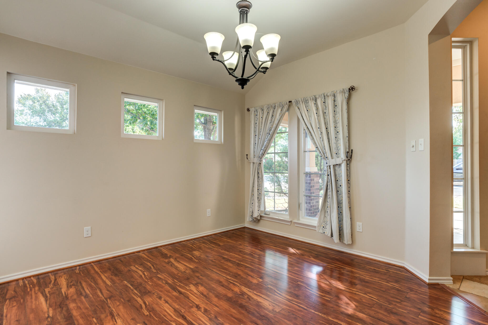 4802 Amherst Street Lubbock, TX 79416 - Photo 16 of 33 a view of an empty room with a window and wooden floor