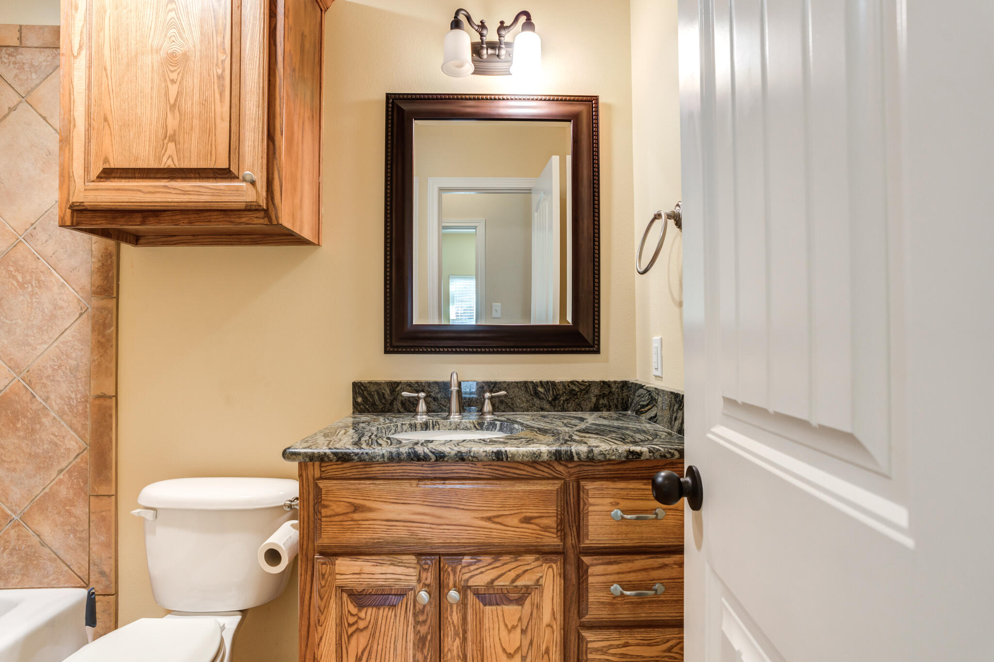 4802 Amherst Street Lubbock, TX 79416 - Photo 18 of 33 a bathroom with a sink a toilet and mirror