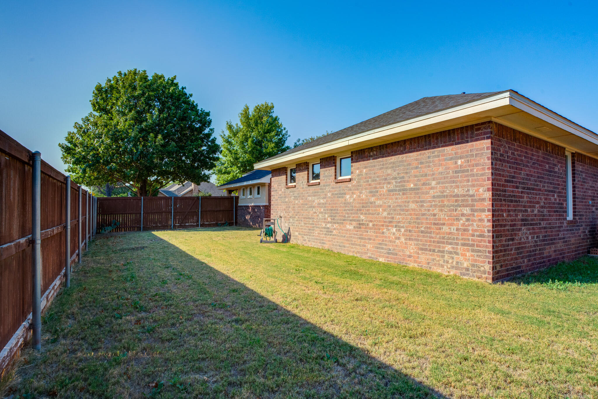 4802 Amherst Street Lubbock, TX 79416 - Photo 33 of 33 a backyard of a house with plants and wooden fence