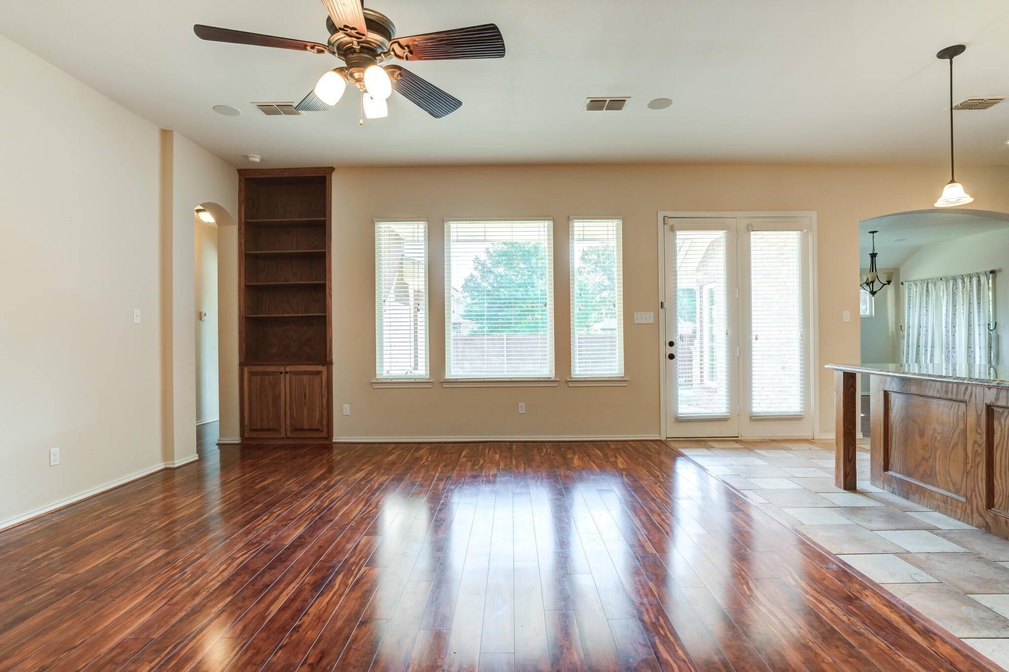 4802 Amherst Street Lubbock, TX 79416 - Photo 8 of 33 a view of an empty room with wooden floor and a window