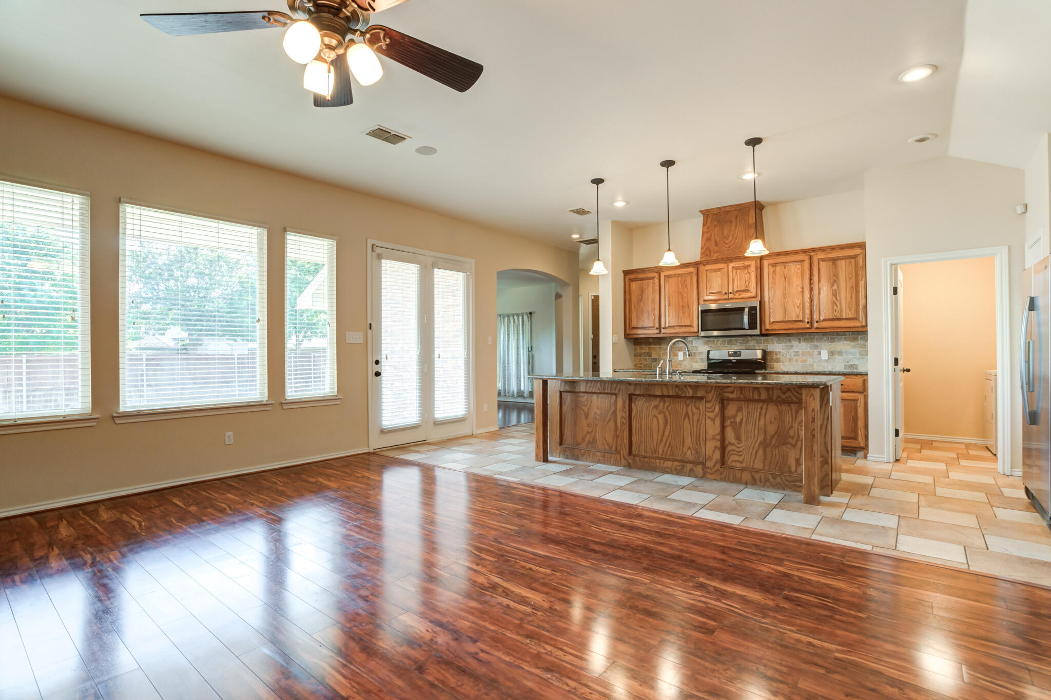 4802 Amherst Street Lubbock, TX 79416 - Photo 9 of 33 a large kitchen with stainless steel appliances granite countertop a stove top oven a refrigerator with island wooden floor and cabinets